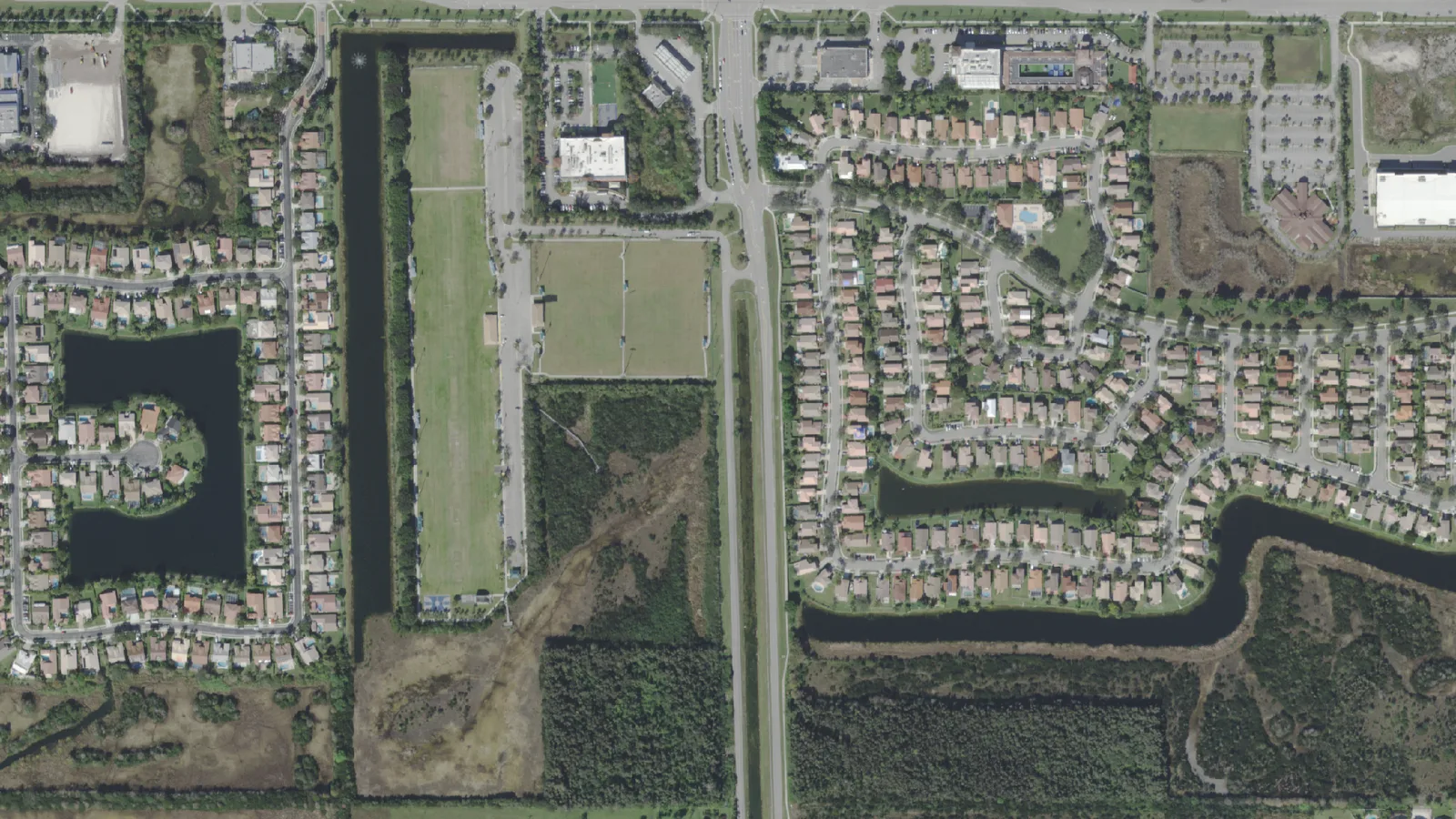 SW 196th Avenue, the road running down the center, south of Pines Boulevard, with West Pines Soccer Park to its west, seen from the air.